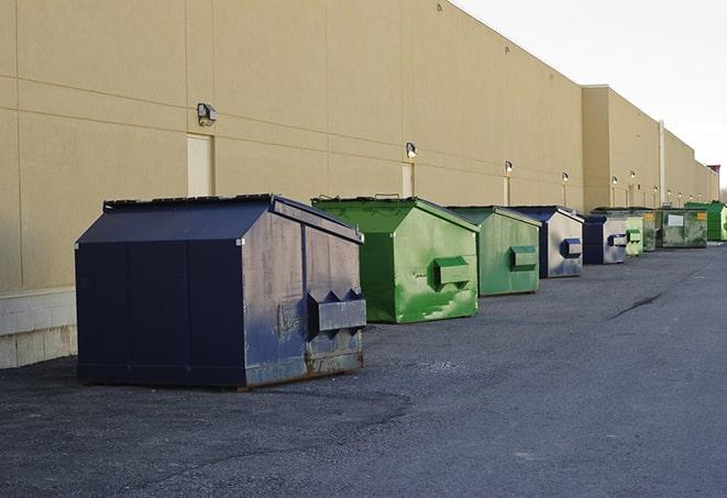 a yellow construction dumpster filled with waste materials in Broadwell